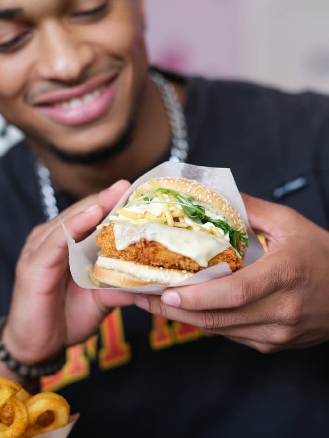Crispy chicken burger entre les mains d'un client