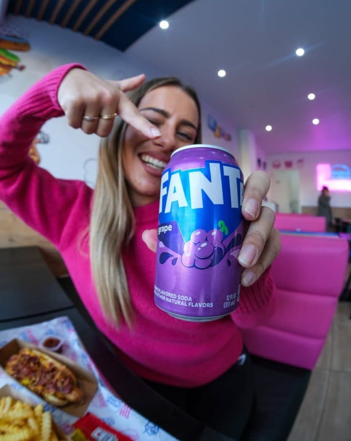 Banquettes roses du restaurant, Fanta Grape à la main